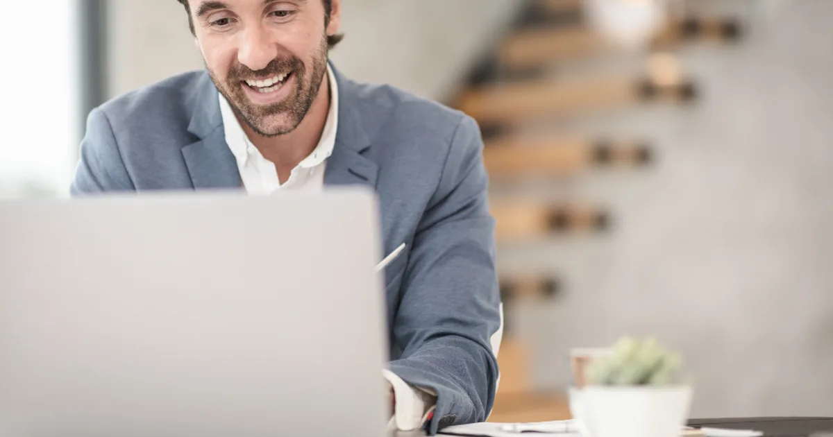 Profesional sonriente en una videollamada desde su laptop