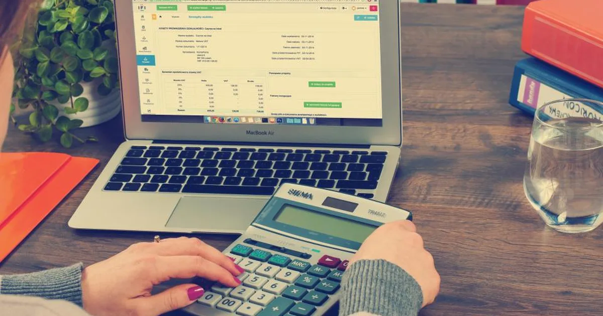 Persona trabajando con una hoja de cálculo en su laptop y una calculadora
